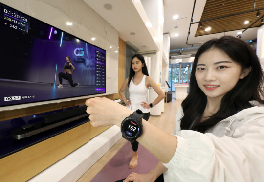 LG유플러스 모델이 U+tv와 갤럭시워치를 연동해 코코어짐 서비스를 이용하고 있고 있다. 연합뉴스